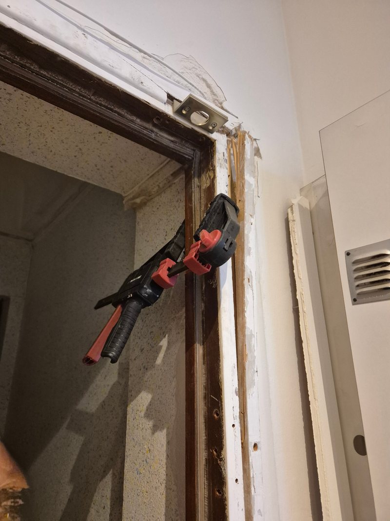 Remise en place du bâti de porte avec serre-joint et nouvelle gâche